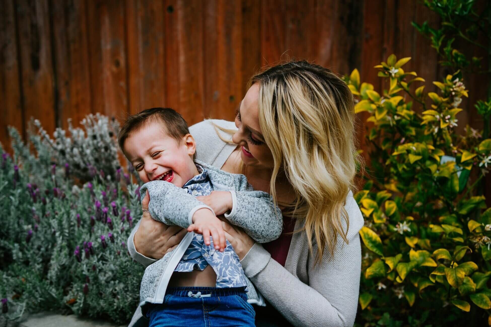 woman holding laughing child in her arms