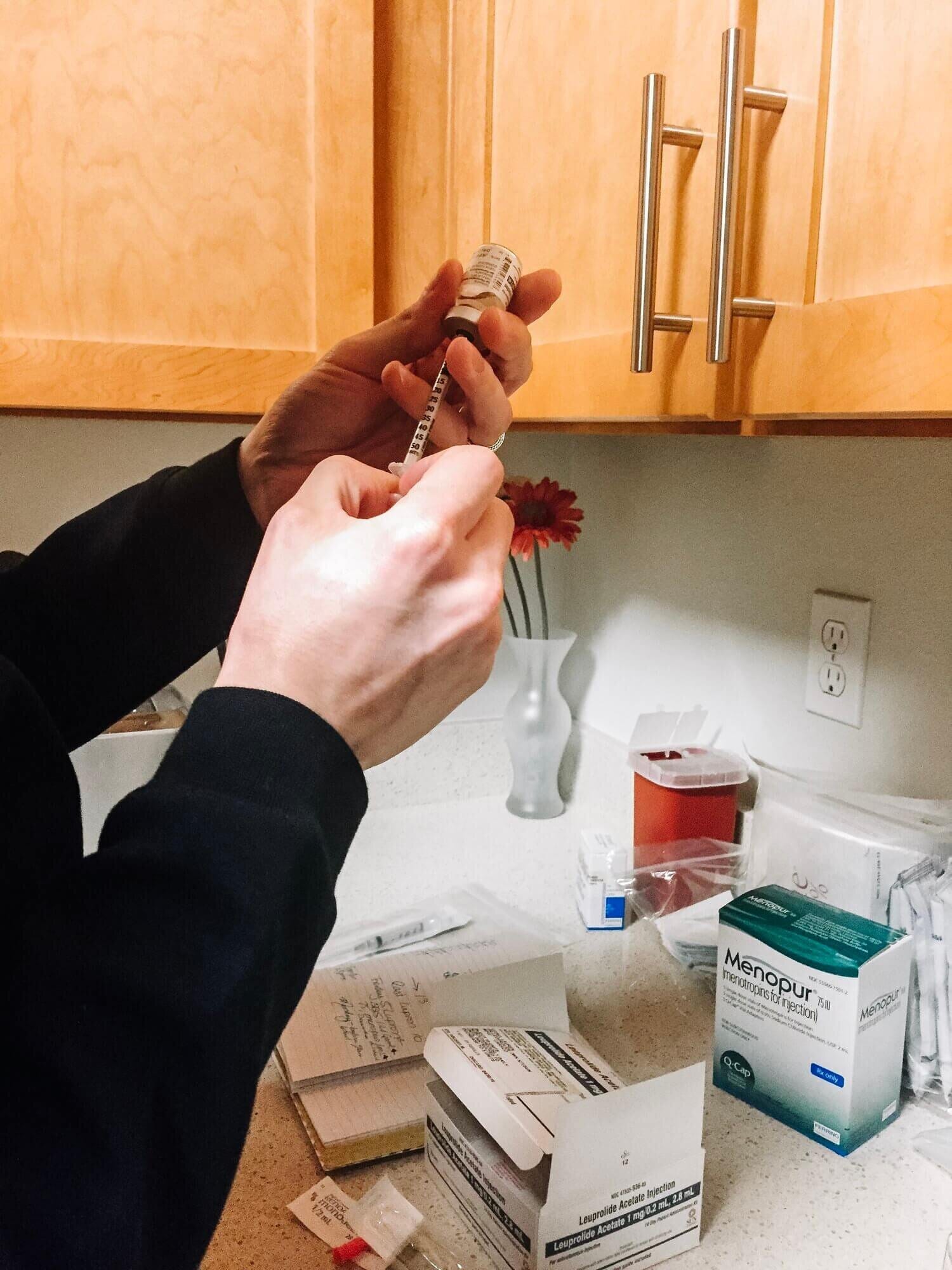 woman looking at her collection of ivf medication