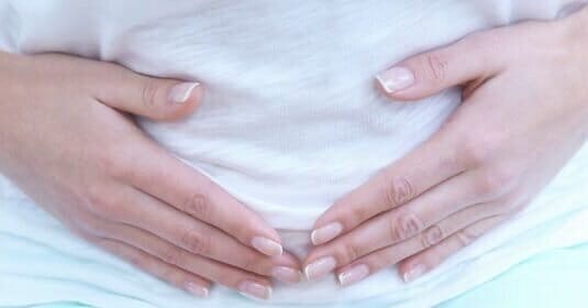 woman cupping her lower abdomen