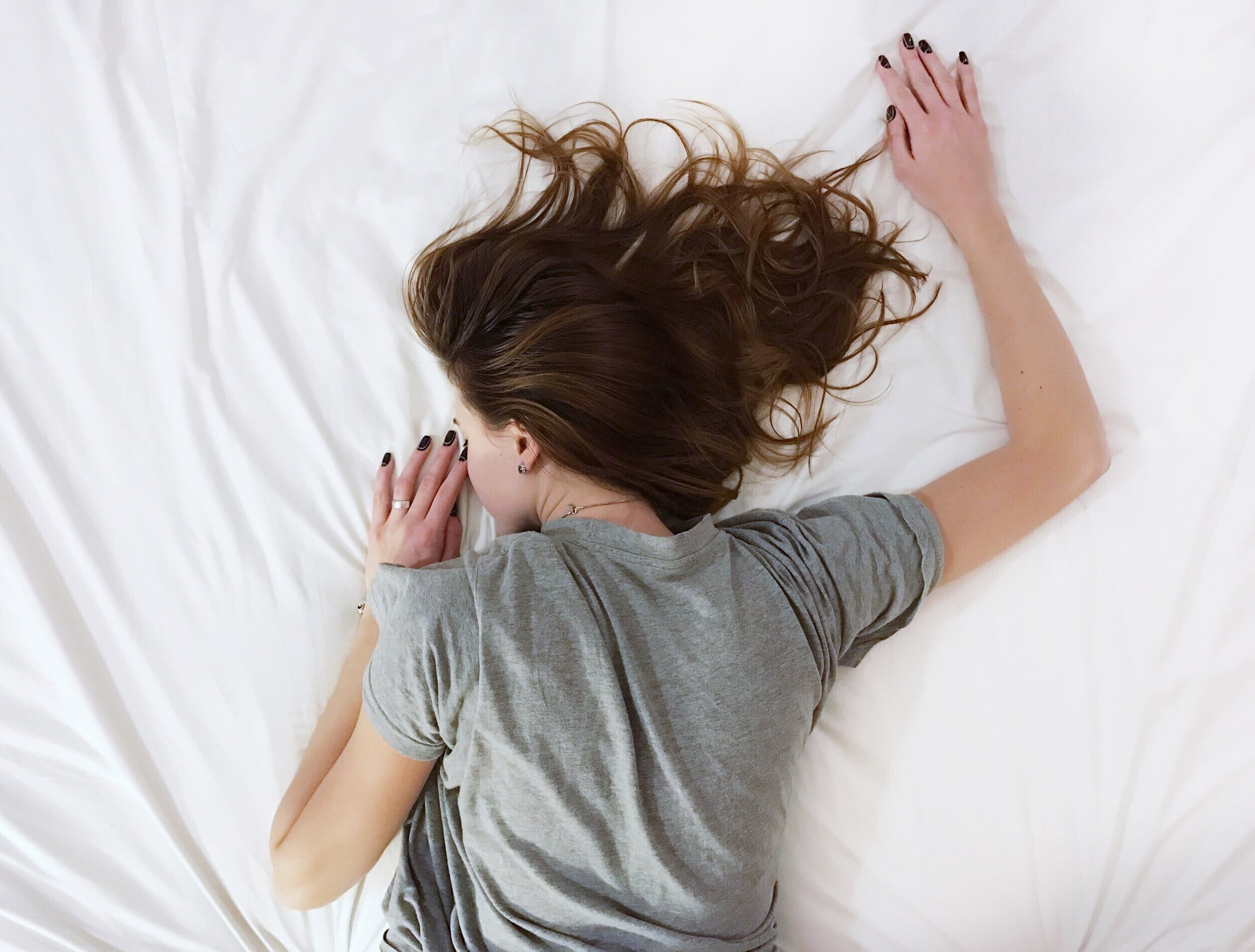 woman lying face down on her bed