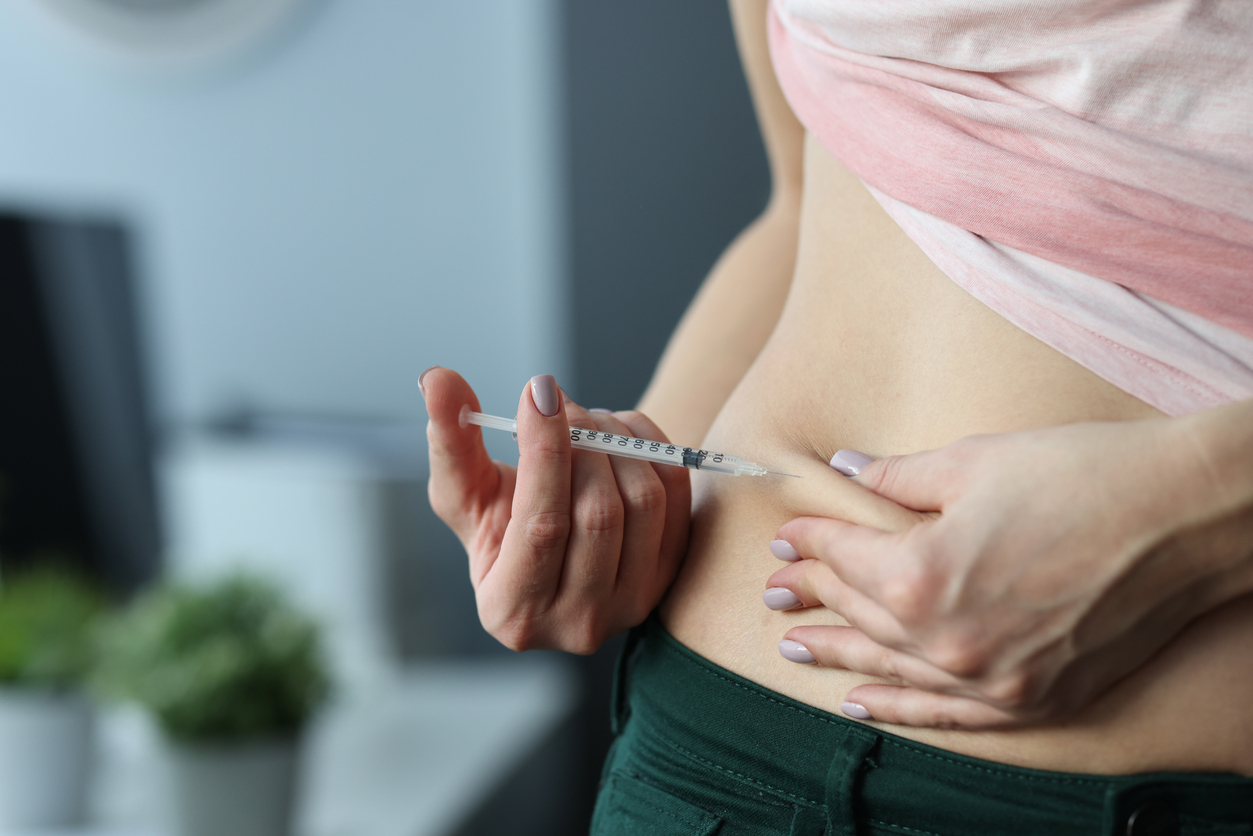 woman injecting herself in the belly with ganirelix