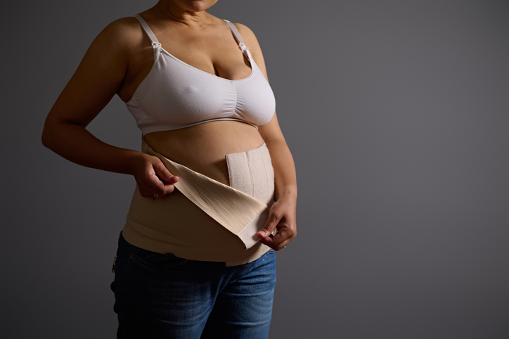 woman using a compression band postpartum