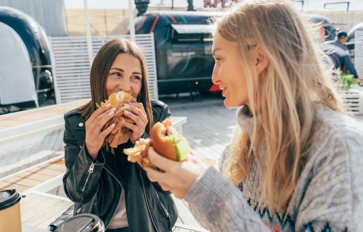 two friends eating sandwiches together