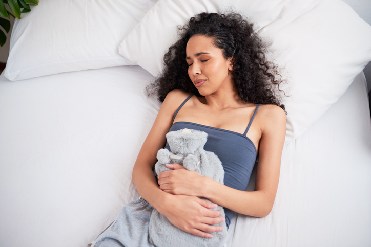 woman with a furry warm water bottle for menstrual cramps