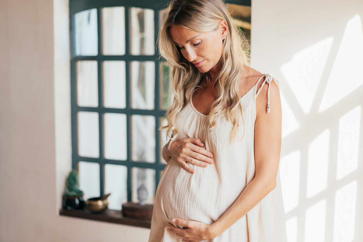 woman cradling her pregnant tummy