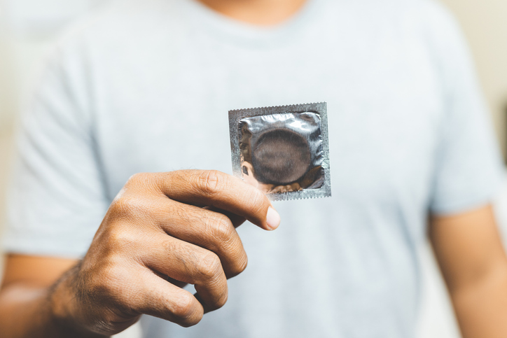 man holding an ultra-thin condom