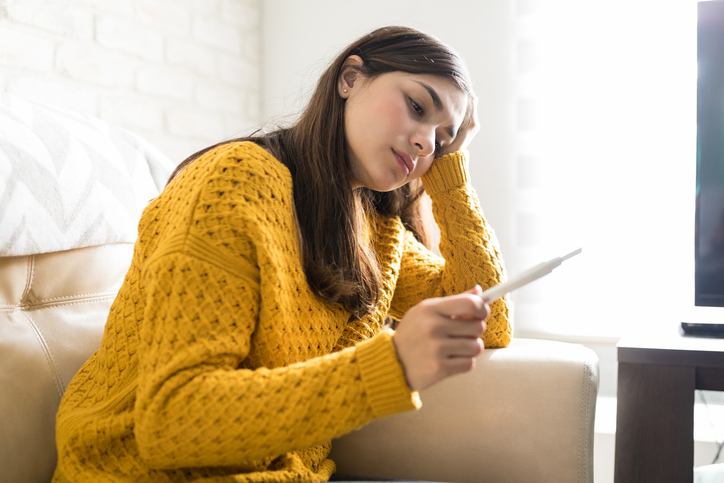 woman looking at pregnancy test with concern