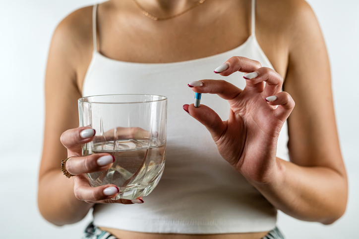 woman holding up a capsule