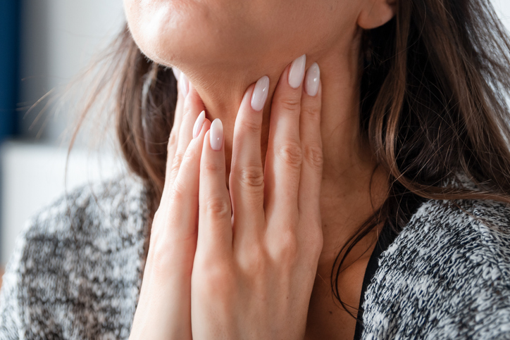 woman examining her thyroid
