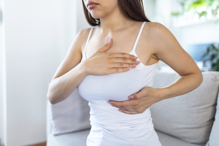 woman cradling her breast as she checks for lumps