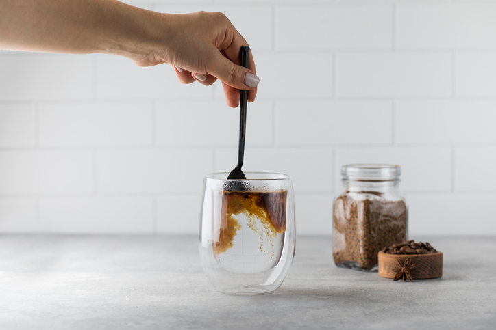 person adding protein powder in coffee