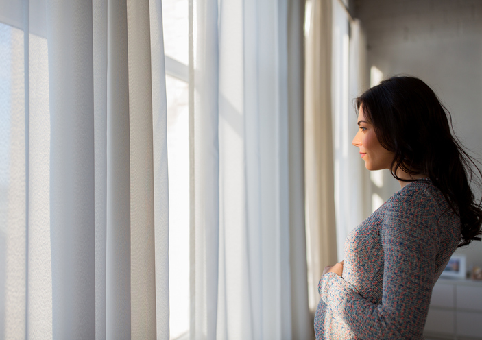 pregnant woman looking out of the window