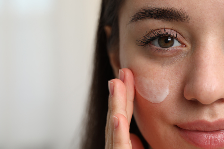 woman applying cream to her cheeks