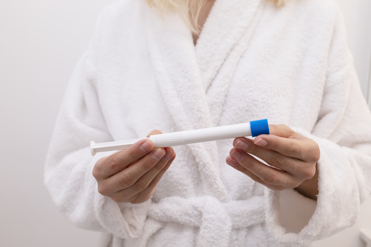 woman holding medication for vaginal burning