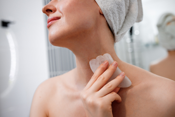 woman doing her gua sha routine after a shower