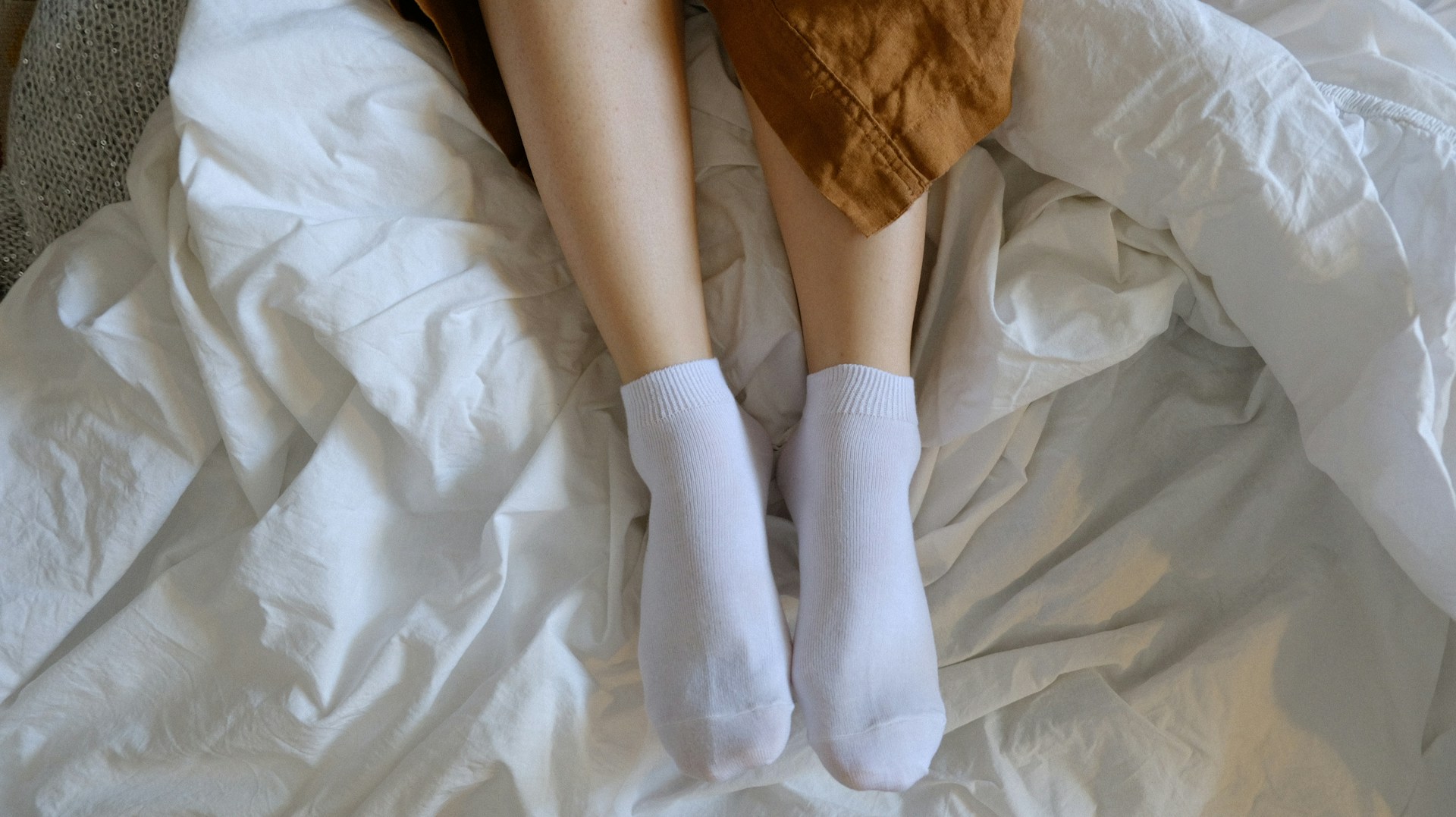 woman legs sticking out from under the covers