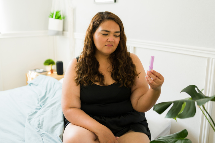 woman looking at a tampon with disgust