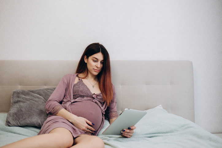 pregnant woman reading on her ipad