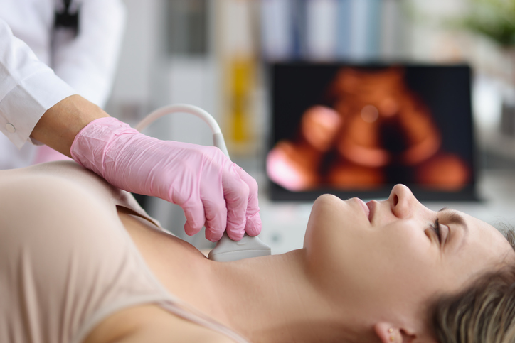 woman having her thyroid evaluated by a doctor