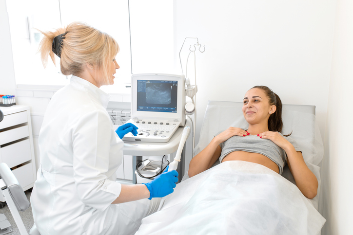 ultrasound technician holding a wand in front of a patient