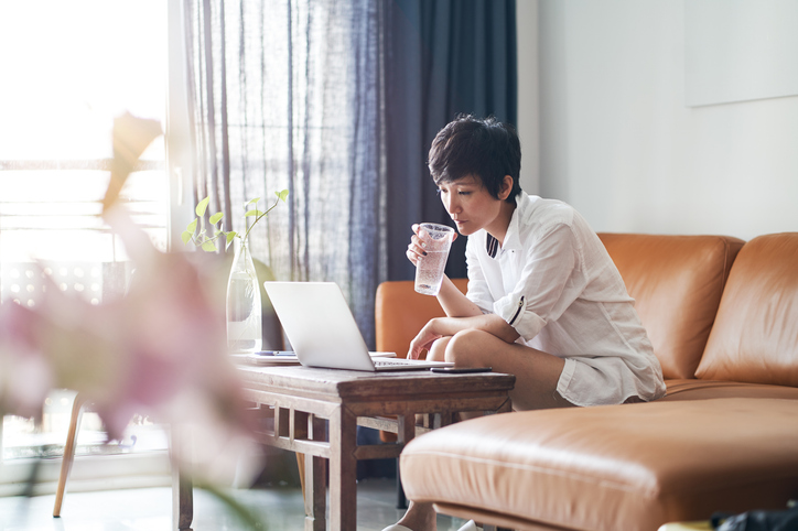 woman drinking water while working