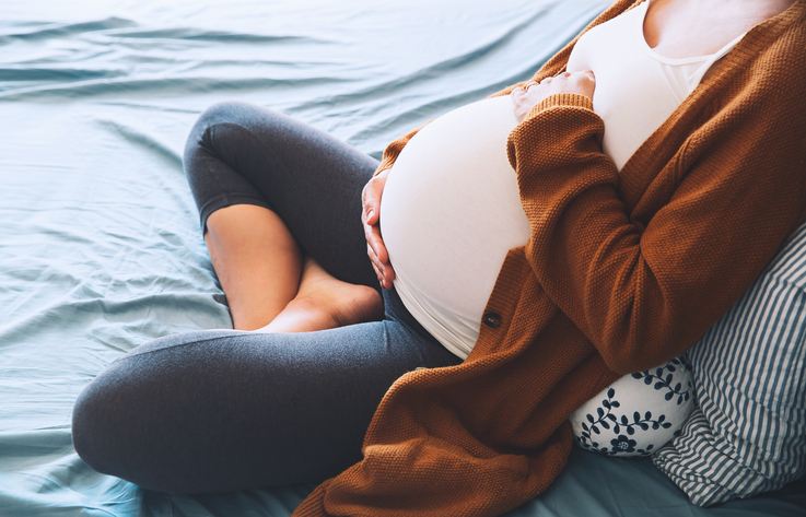 pregnant woman cradling her belly
