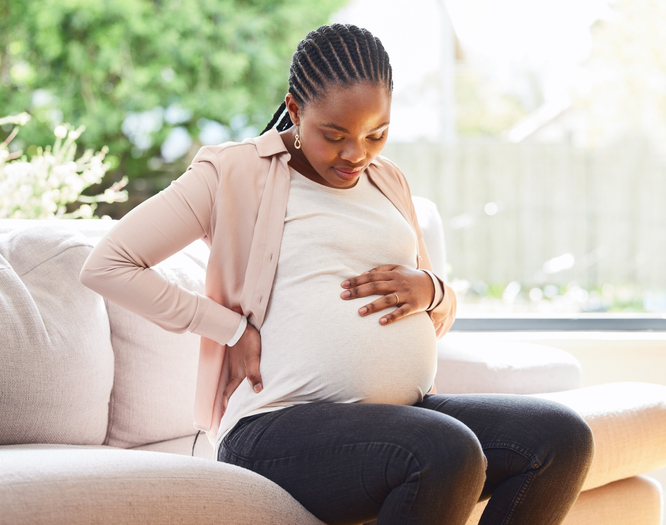 pregnant woman looking at her protruding belly