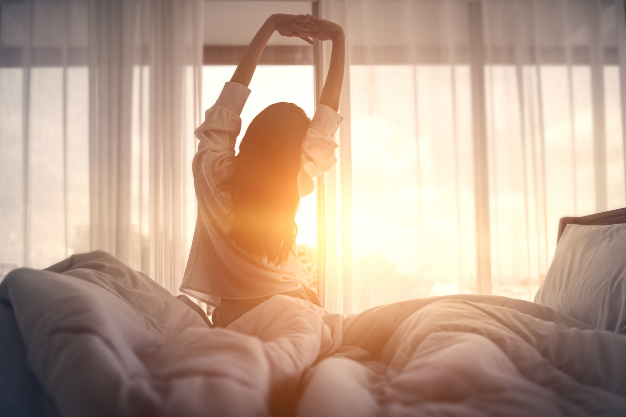 well rested woman waking up to the sun
