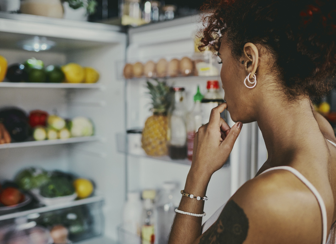 woman looking in the fridge for healthy snack options