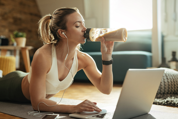 woman drinking a smoothie post-workout