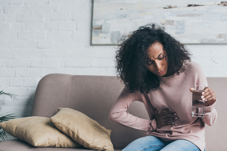 woman feeling gas pains and needing to poop on her period