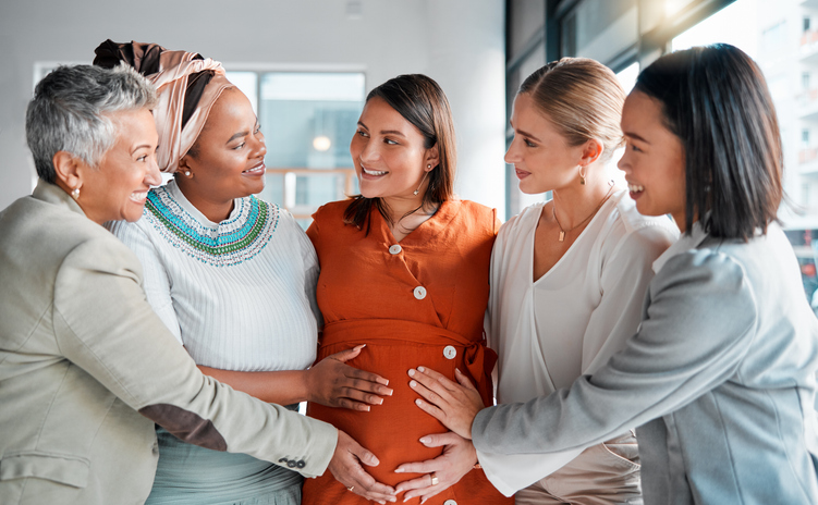 family and friends gather around pregnant woman at a nesting party