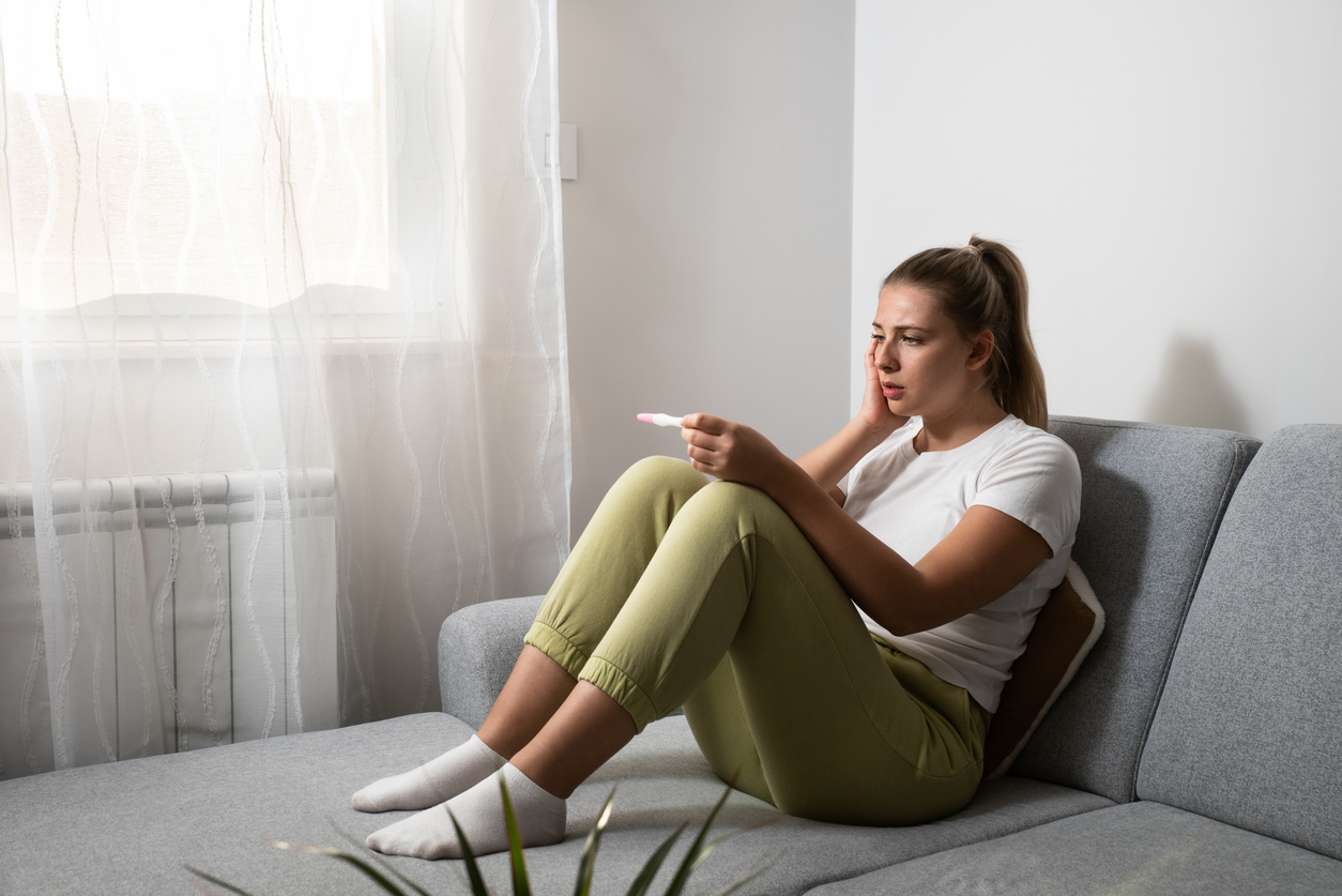 woman worried about miscarriage looking at a pregnancy test