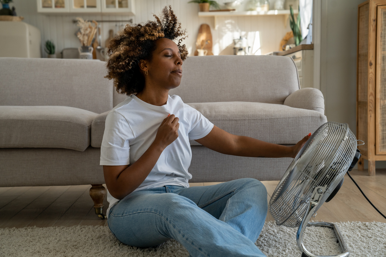 woman struggling through hot flashes during period