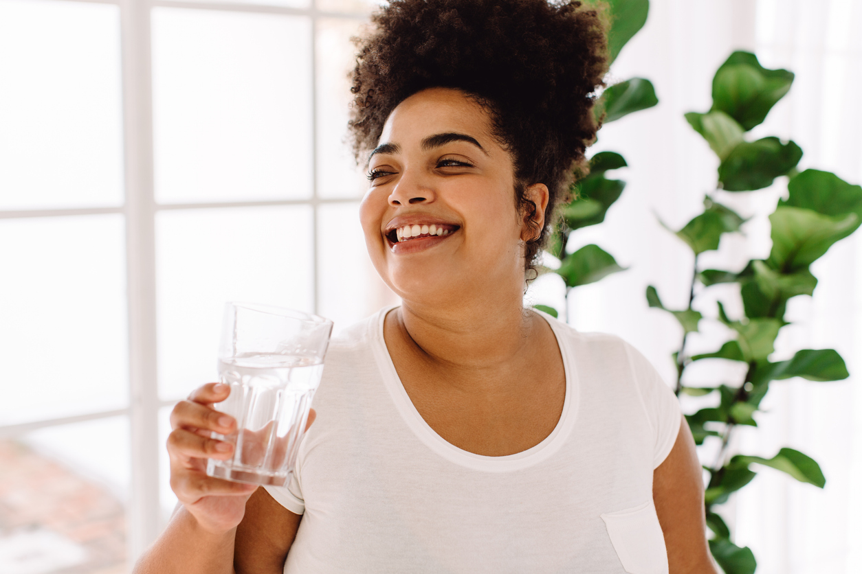 woman staving off a perimenopausal hot flash by drinking cold water