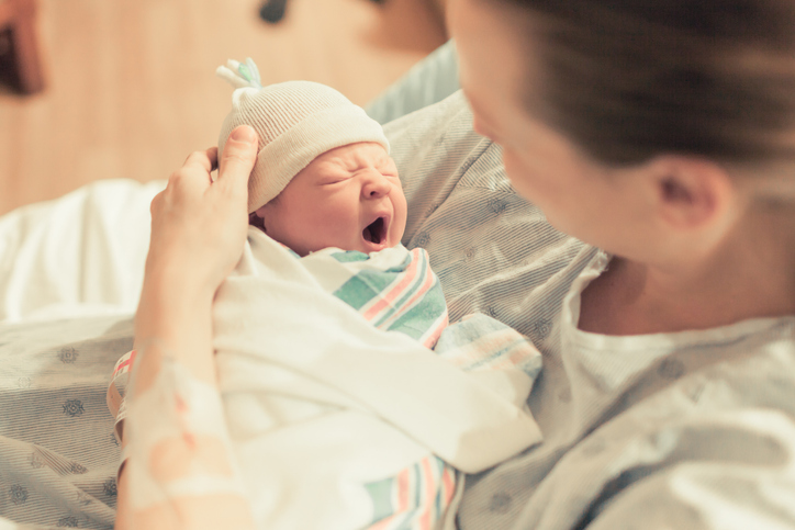 woman holding her newborn baby