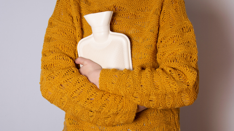 woman holding a hot water bottle for ovulation pain