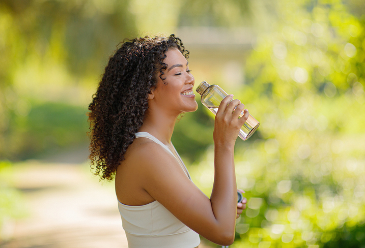 healthy woman drinking water outdoors