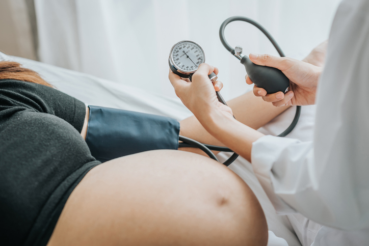 pregnant woman having her blood pressure checked by her obgyn