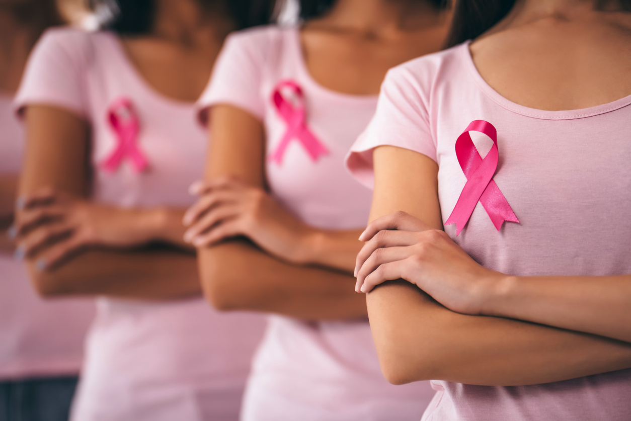 rows of women wearing pink and pink ribbons in support of breast cancer awareness