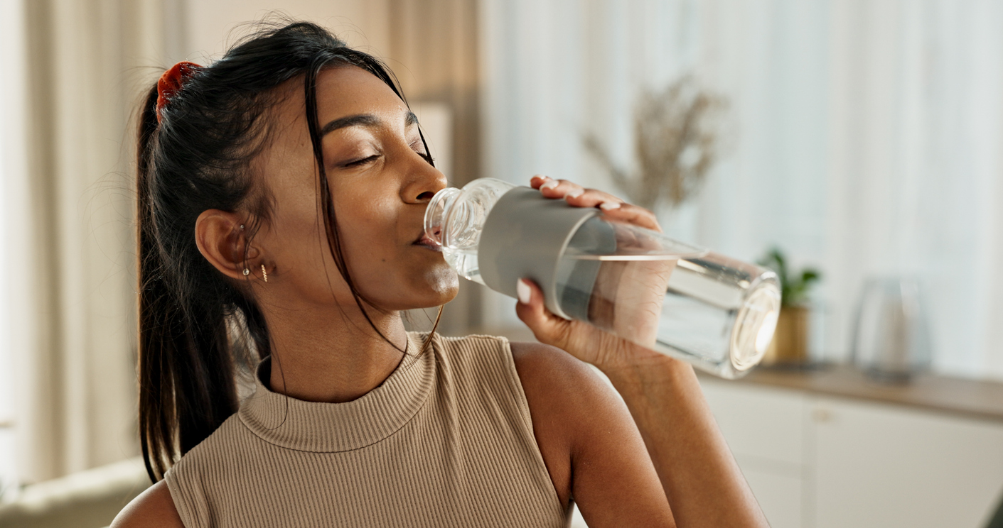 woman drinking water to alleviate a uti