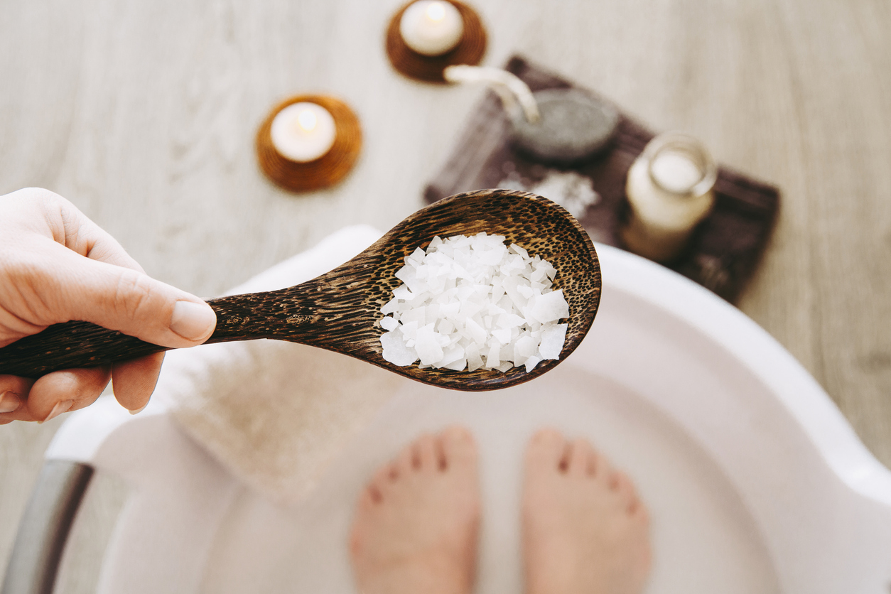 woman doing a foot bath with epsom salts that contain magnesium