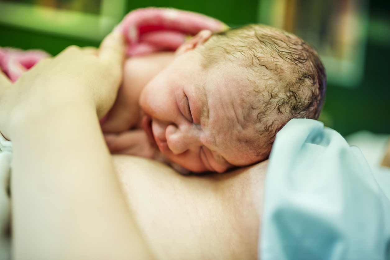 newborn baby resting on mom