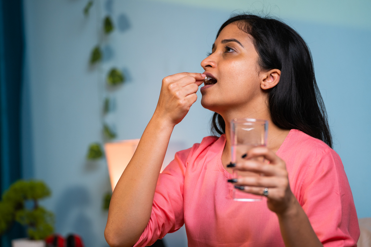 woman taking prenatal vitamins postpartum