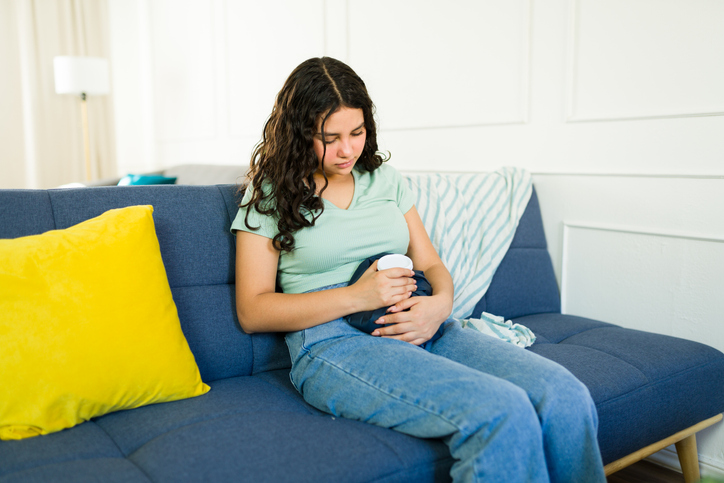 woman using a hot water bottle for menstrual cramps