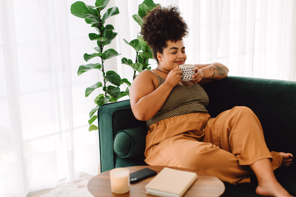 woman enjoying coffee on her couch