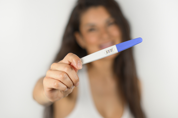 woman holding up a positive pregnancy test