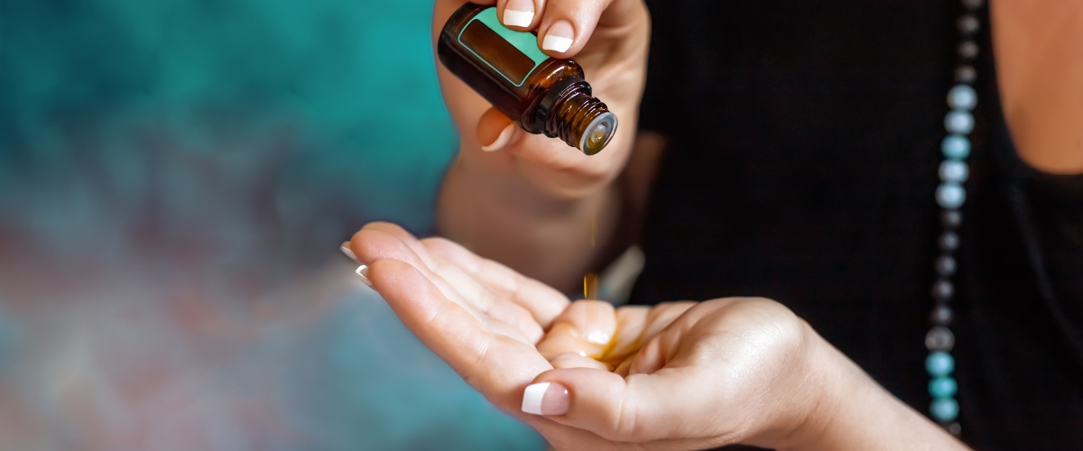 woman pouring castor oil from a small bottle