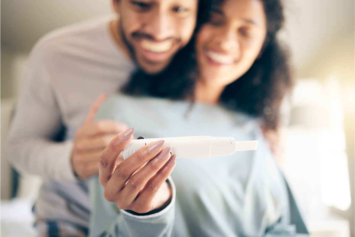 couple with positive pregnancy stick