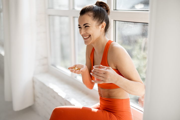 woman taking supplements after working out